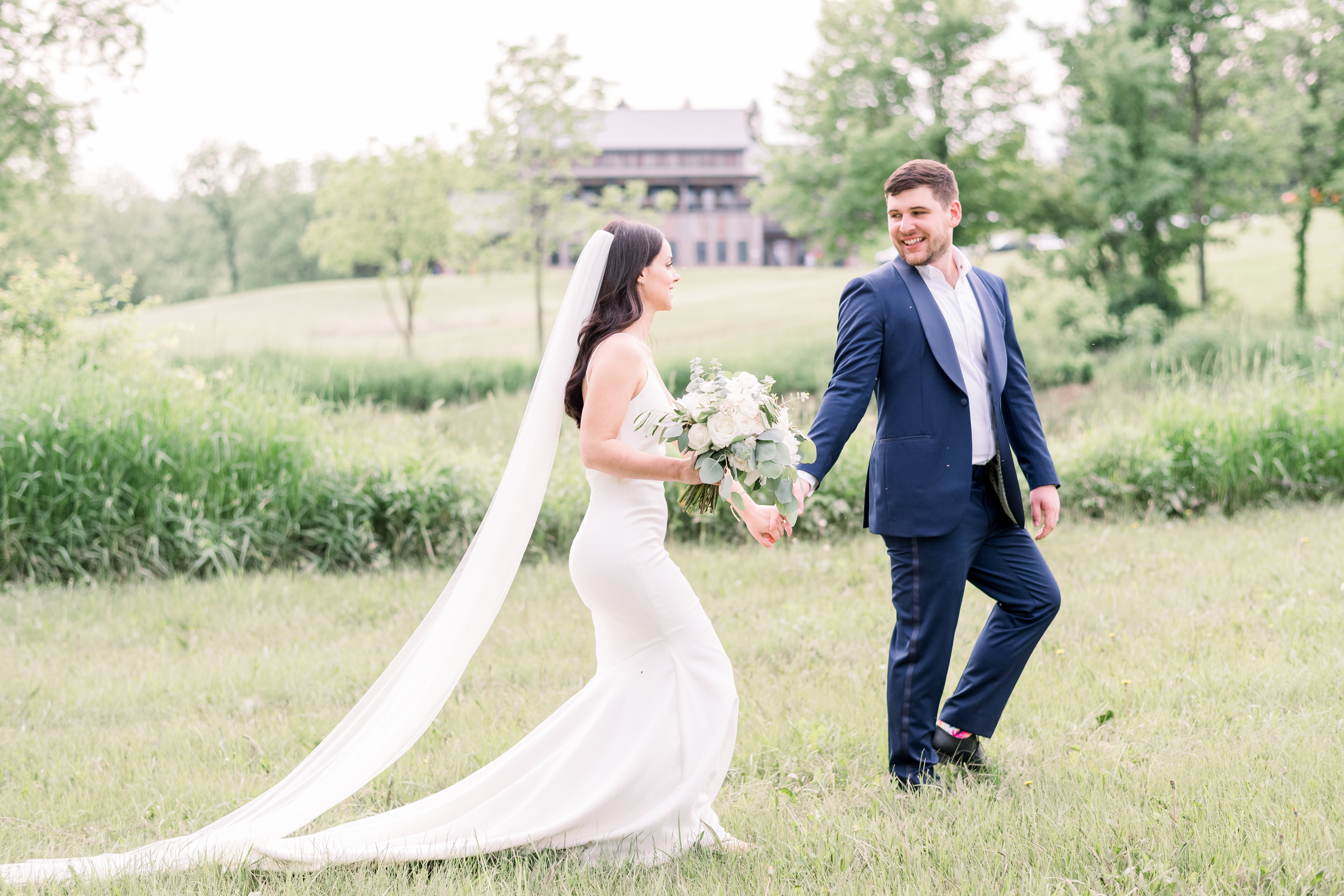 Bride and groom walking in a field in Iowa City, Iowa